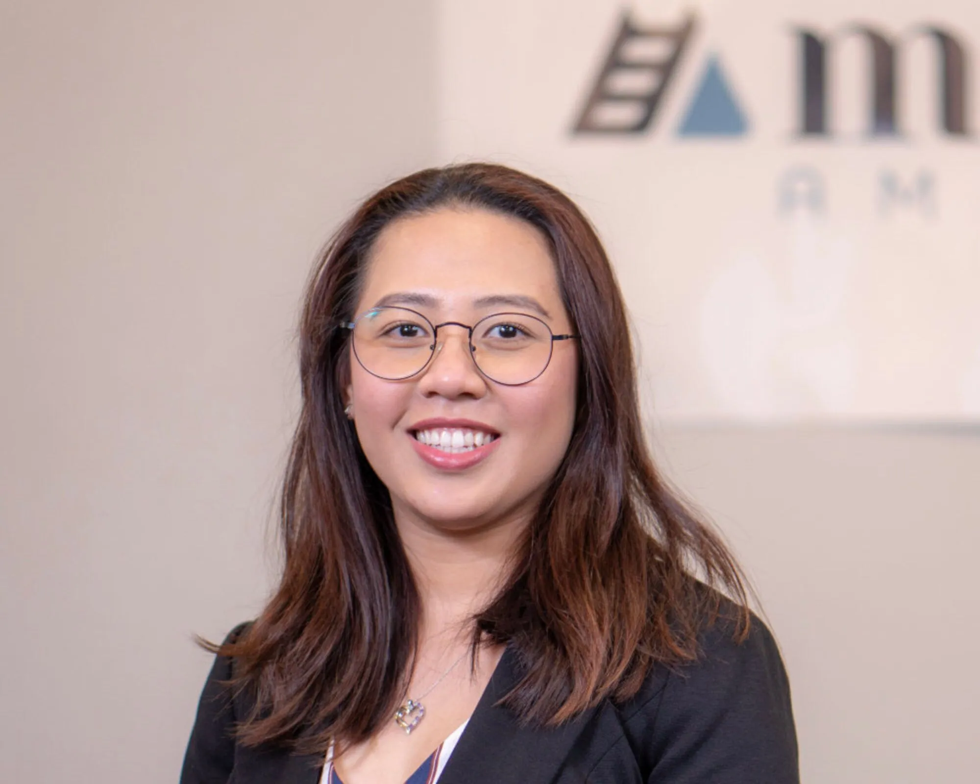 Vi, a Merit America alumni, stands smiling at the camera.