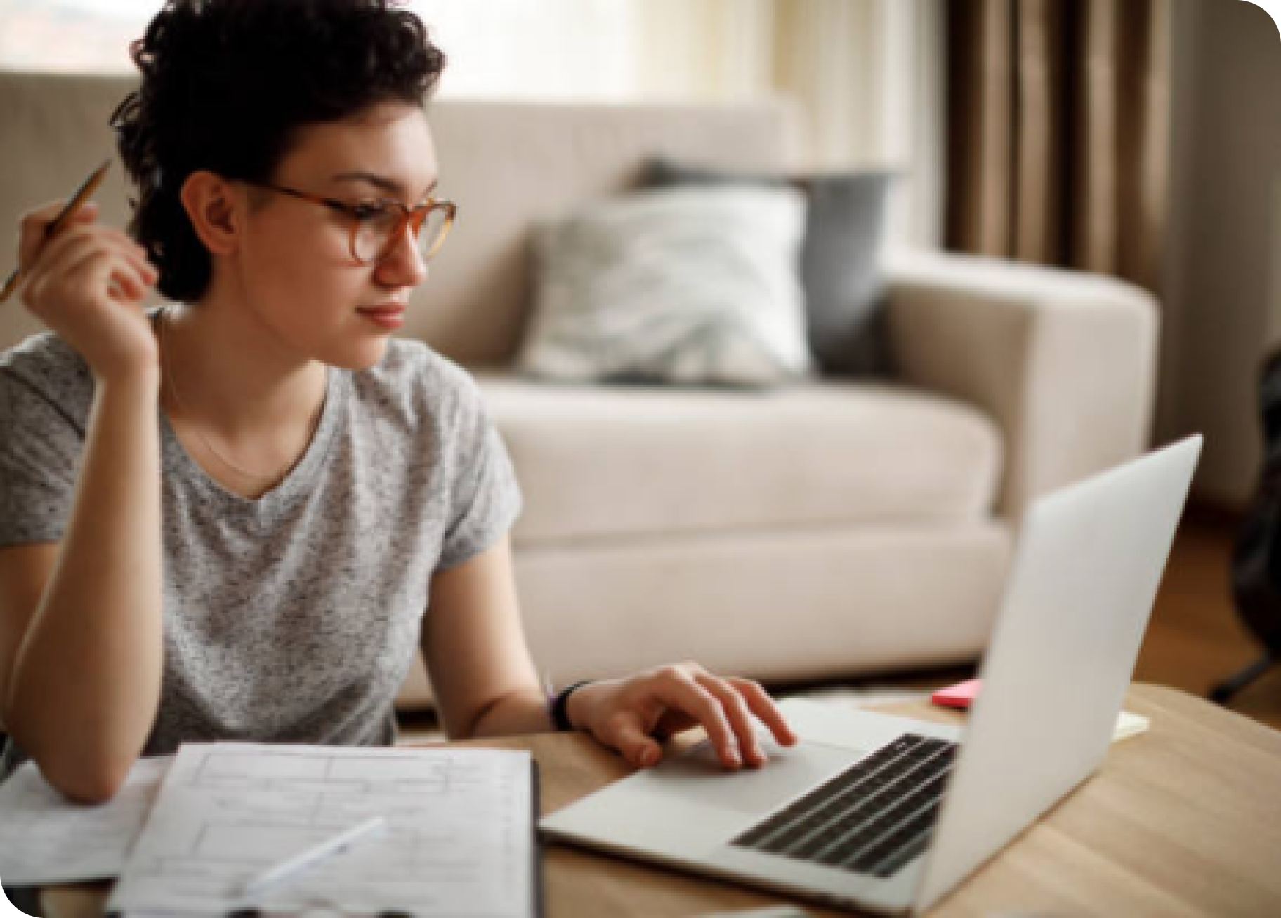 A woman sits at her desk with a pencil in hand.