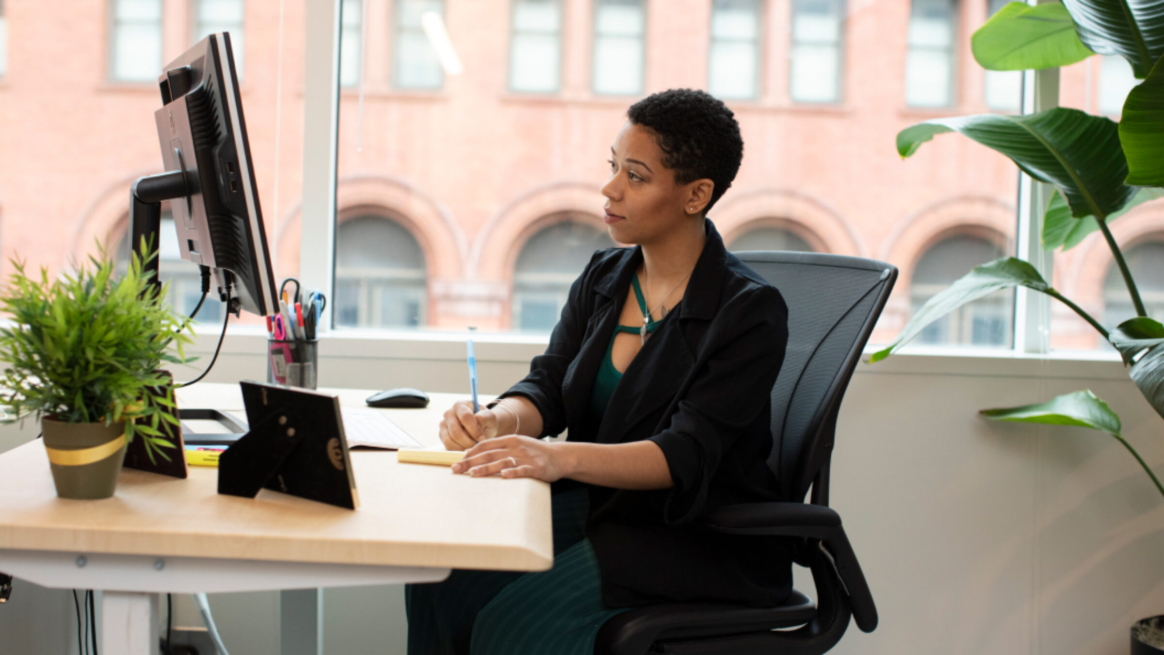 A photo of a woman sitting at a desktop.