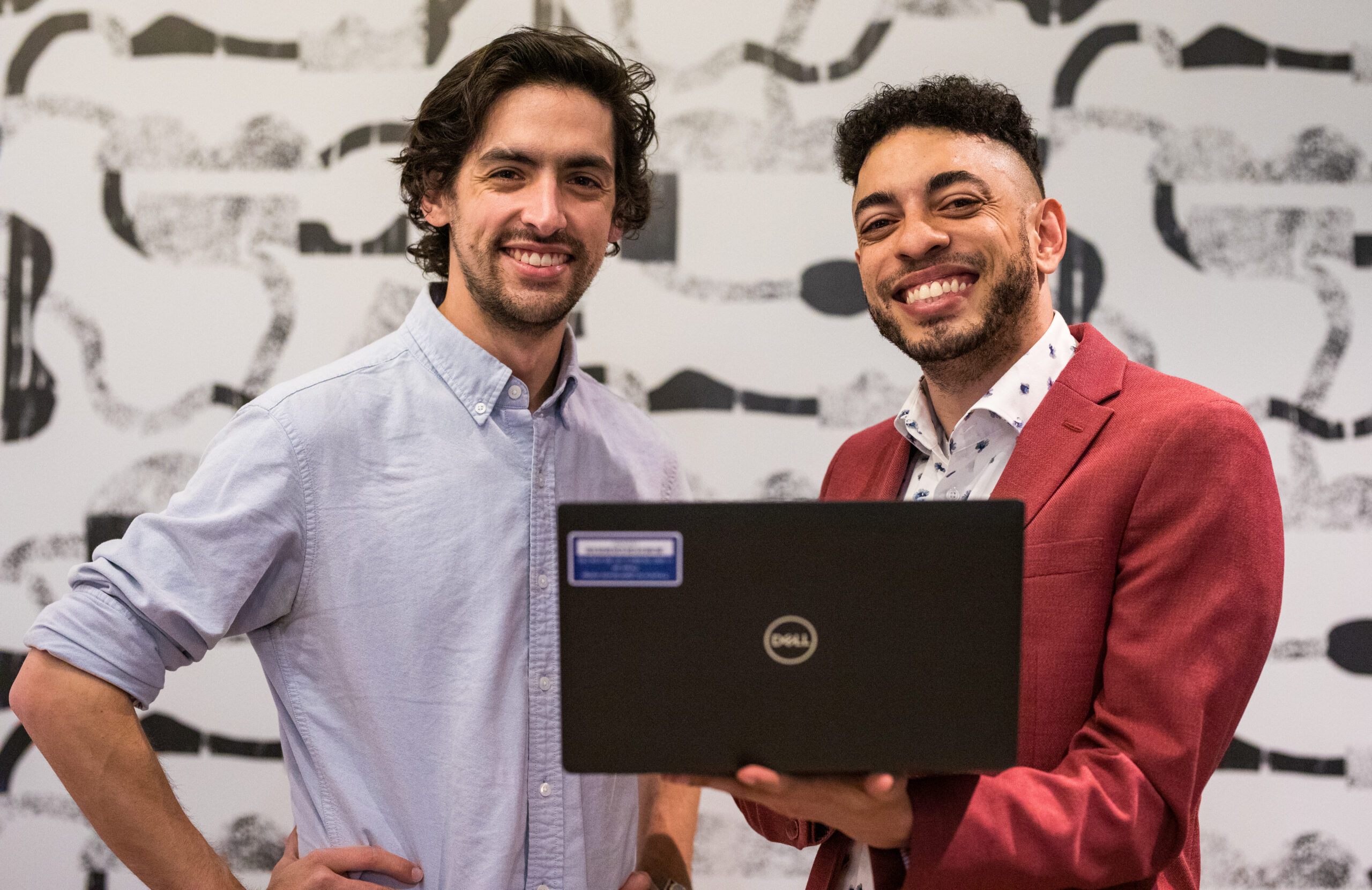 Two Merit America alumni working through something together at a laptop