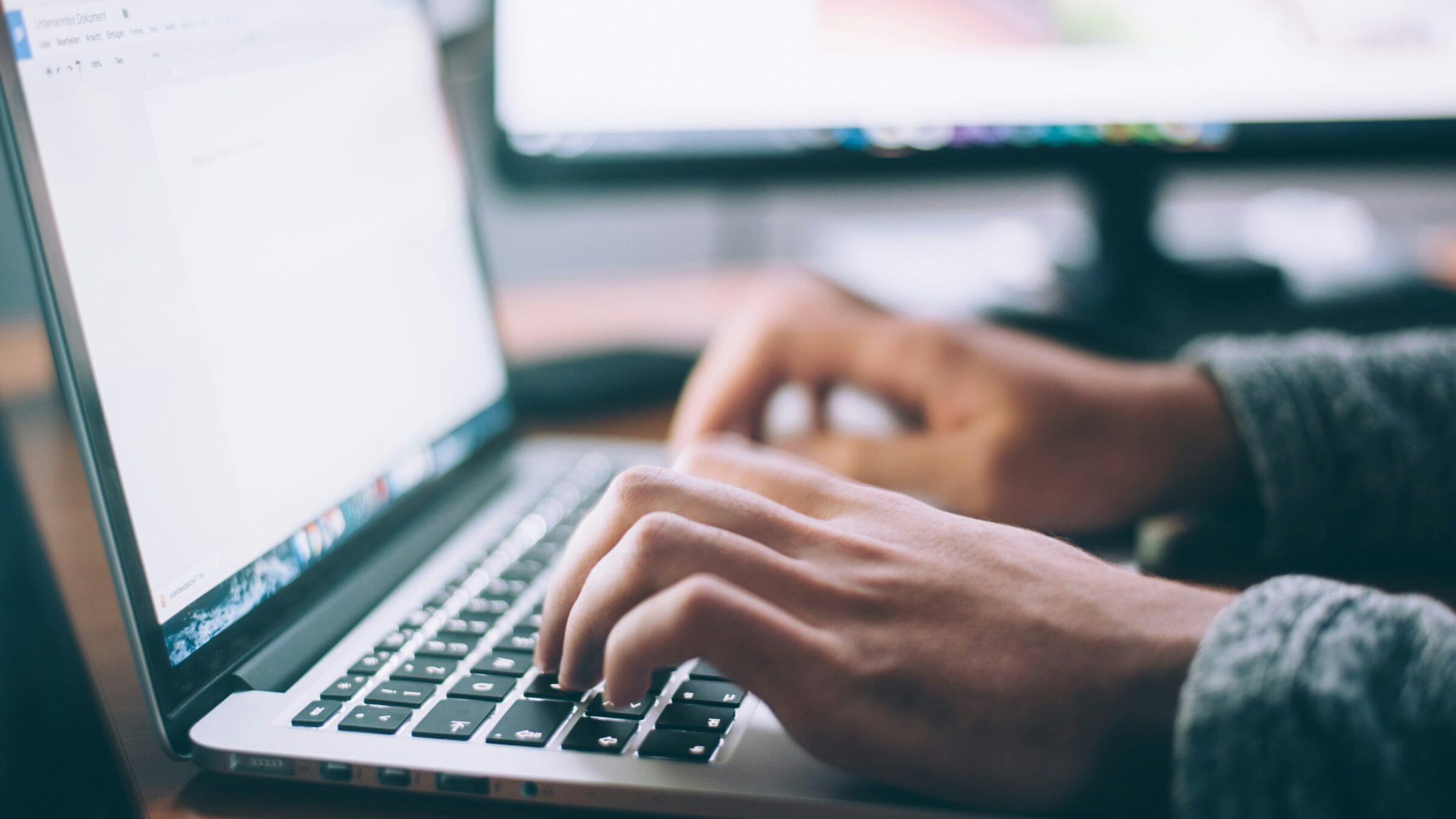 Hands typing on a computer.