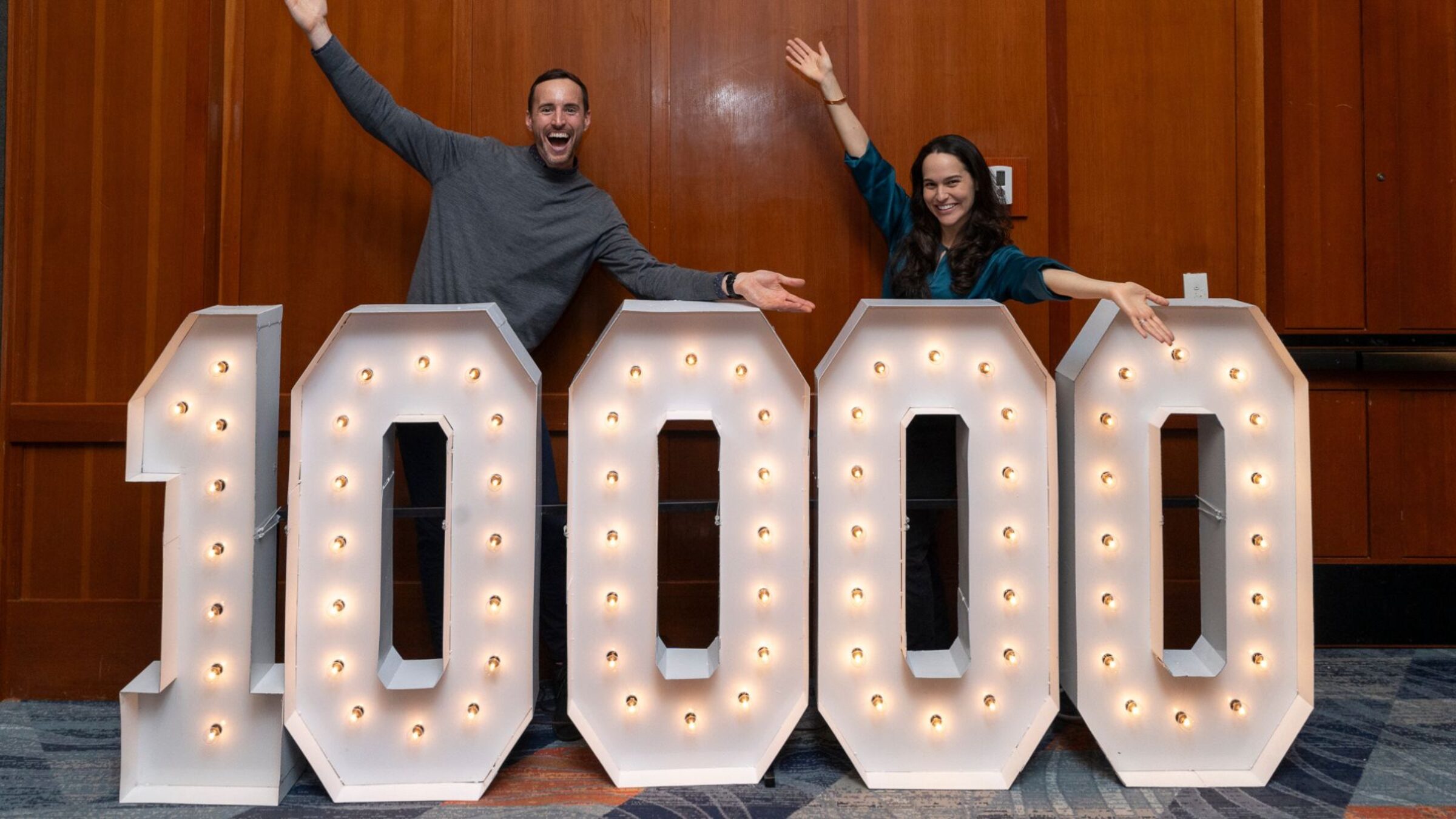 Merit America Co-CEOs behind a 10,000 sign.