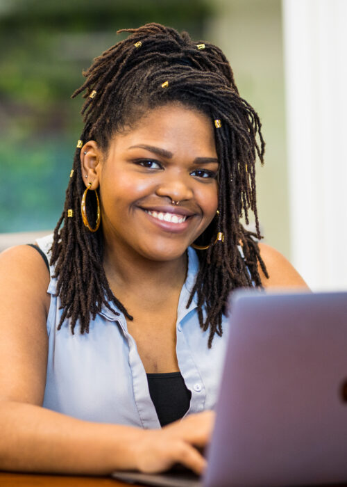 A Merit America alumni smiling during job training.