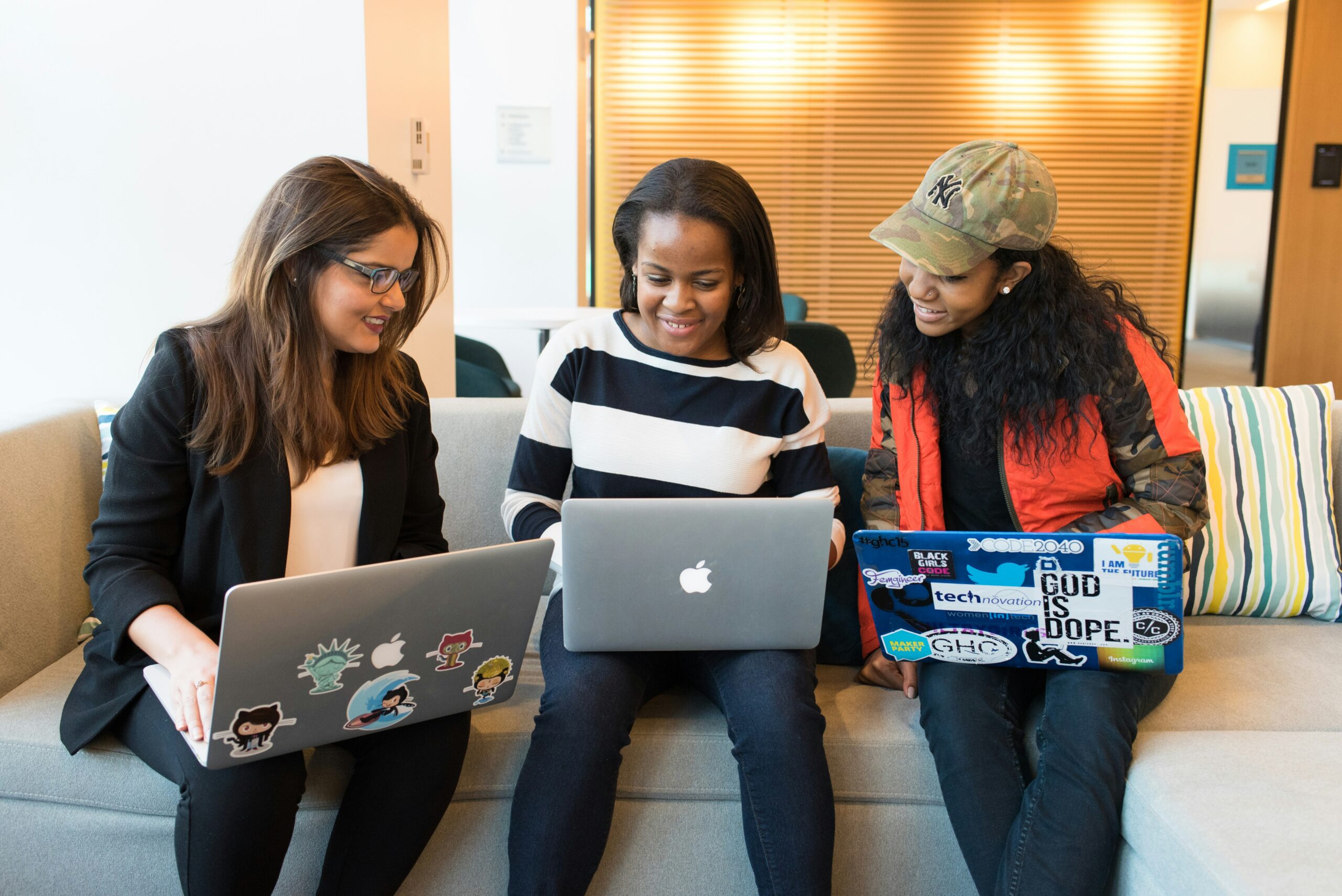 A group of Merit America learners gathered around a laptop.