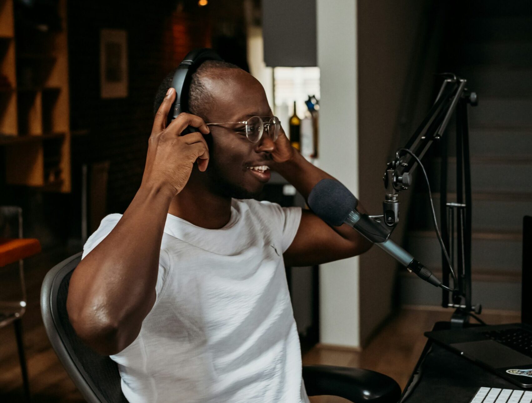 A man settles behind a microphone preparing for a podcast.