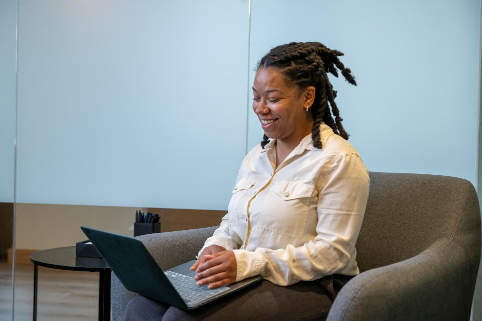 A Merit America learner smiling at a laptop.