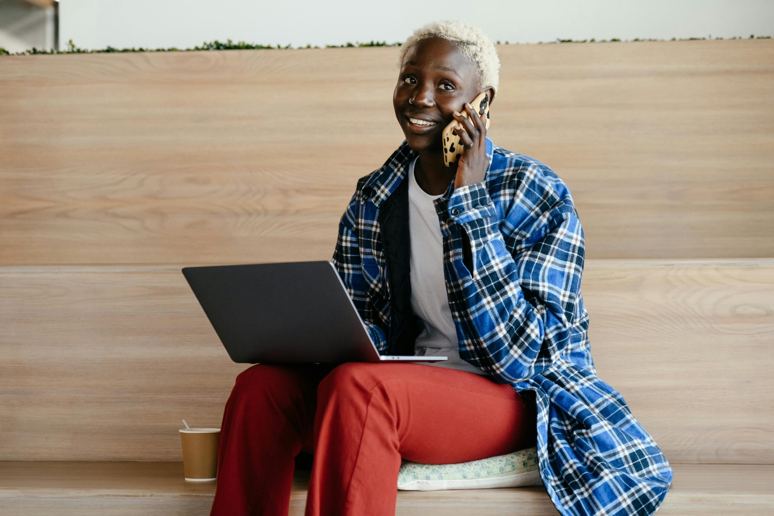 A photo of a person on the phone smiling.