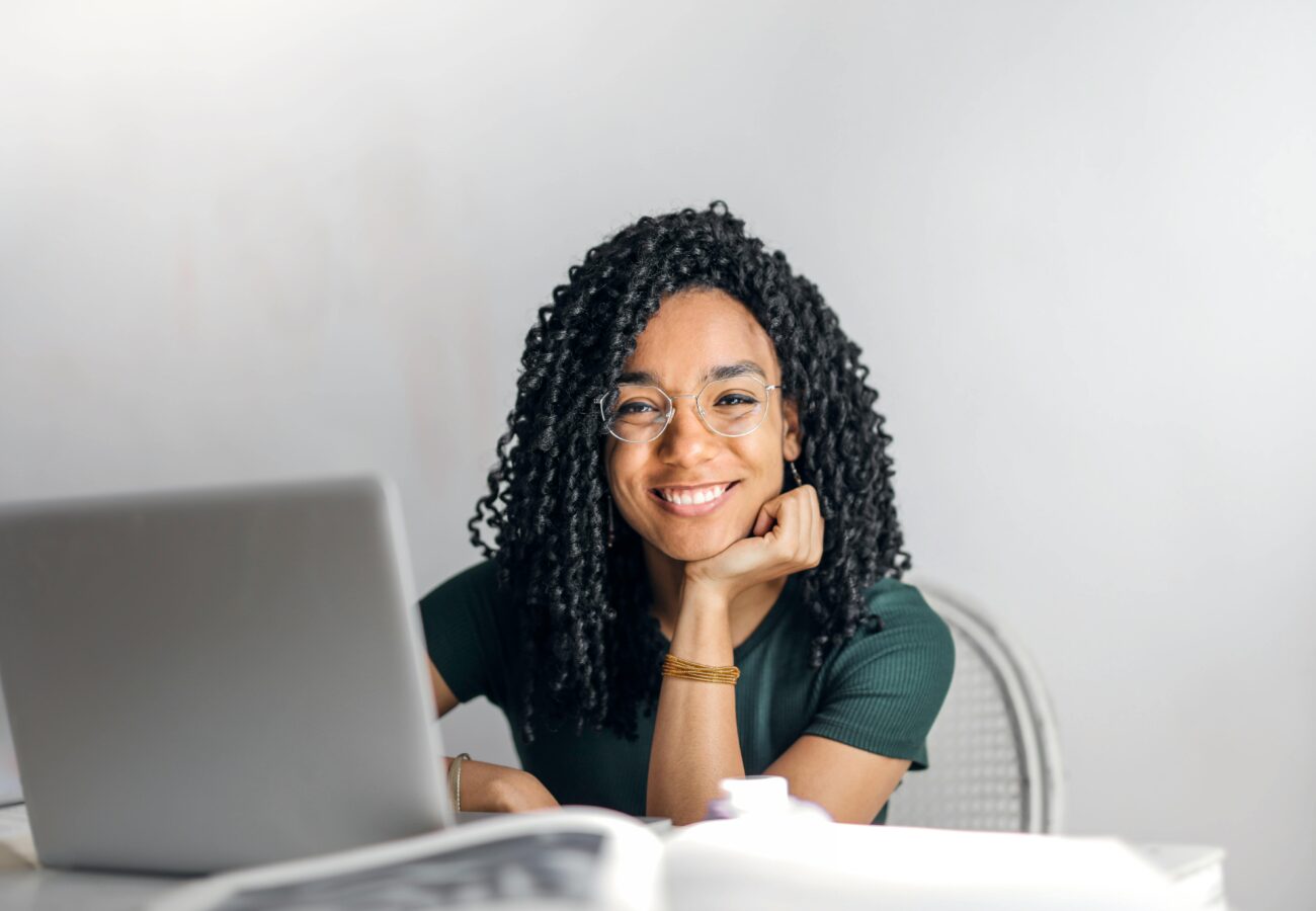 A woman sits and stares into the screen.