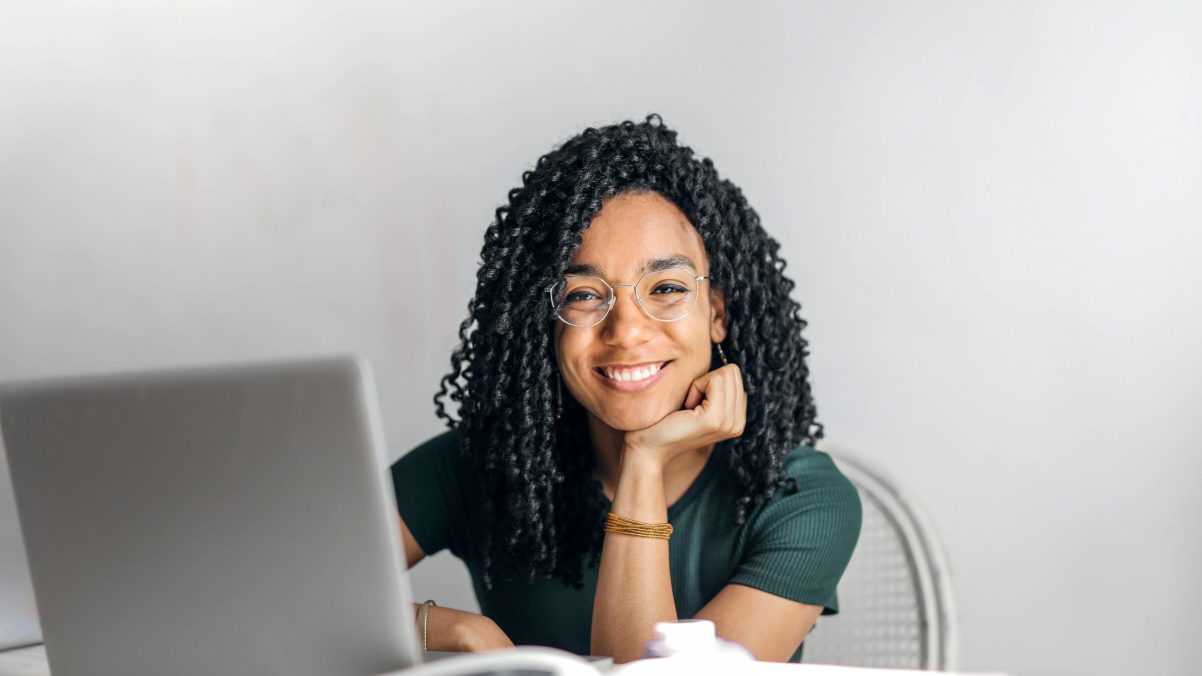 A woman sits and stares into the screen.