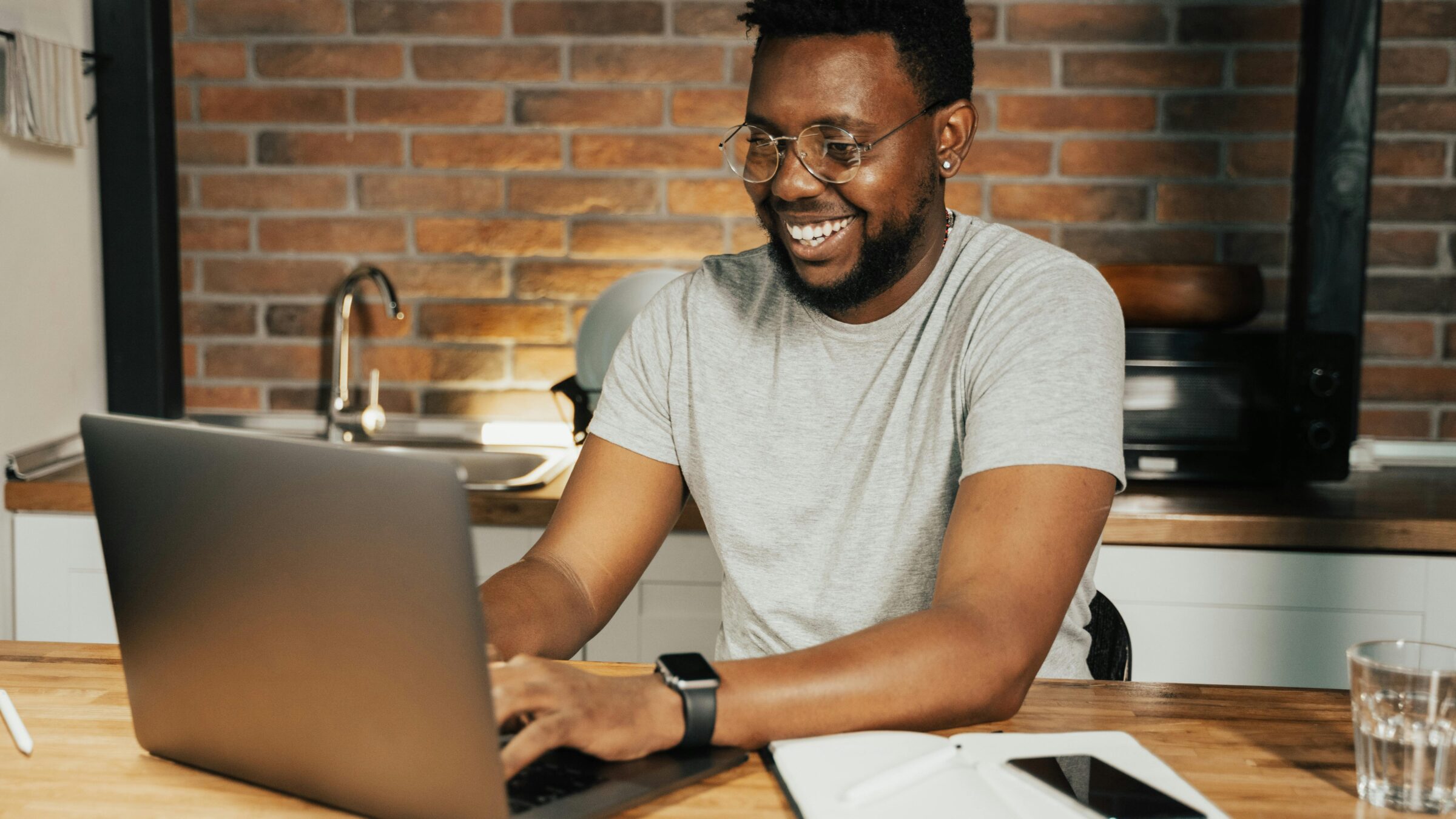 A man smiling on a laptop.