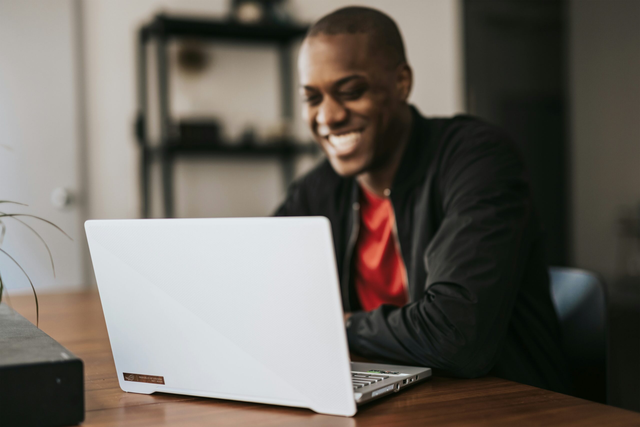 A man smiling at the laptop